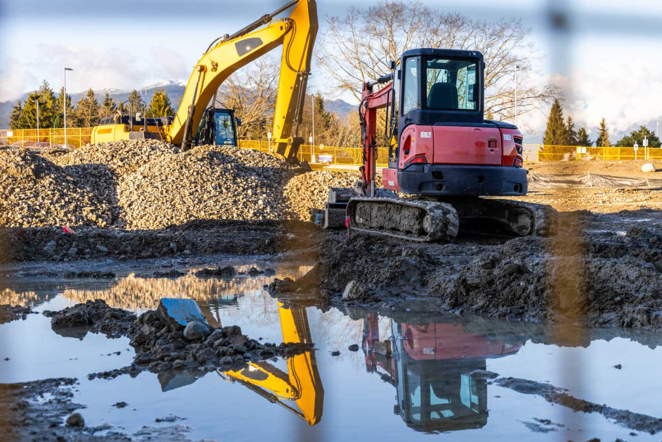 Deux engins de chantier en train de manœuvrer sur un terrain en cours d'aménagement